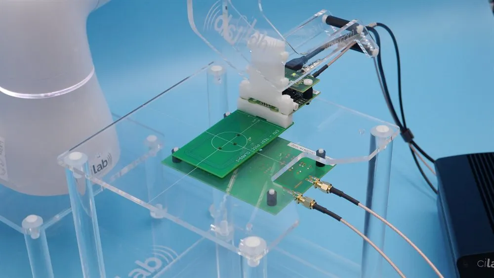 An EMV® TEST-PCD reference reader antenna on the cilab acrylic test rig, robot-positioned and connected to the ci230