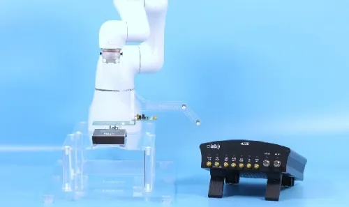 Robot arm positioning a device over a contactless test antenna